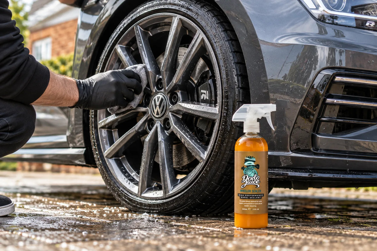 Dodo Juice Wheeler Sealer 500ml beside a Volkswagen Golf R alloy wheel being wiped with a microfibre cloth