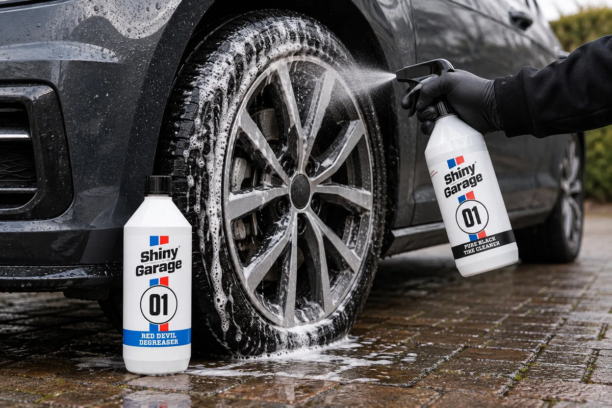Shiny Garage Pure Black Tire Cleaner sprayed onto a foamed alloy wheel beside a bottle of Red Devil Degreaser