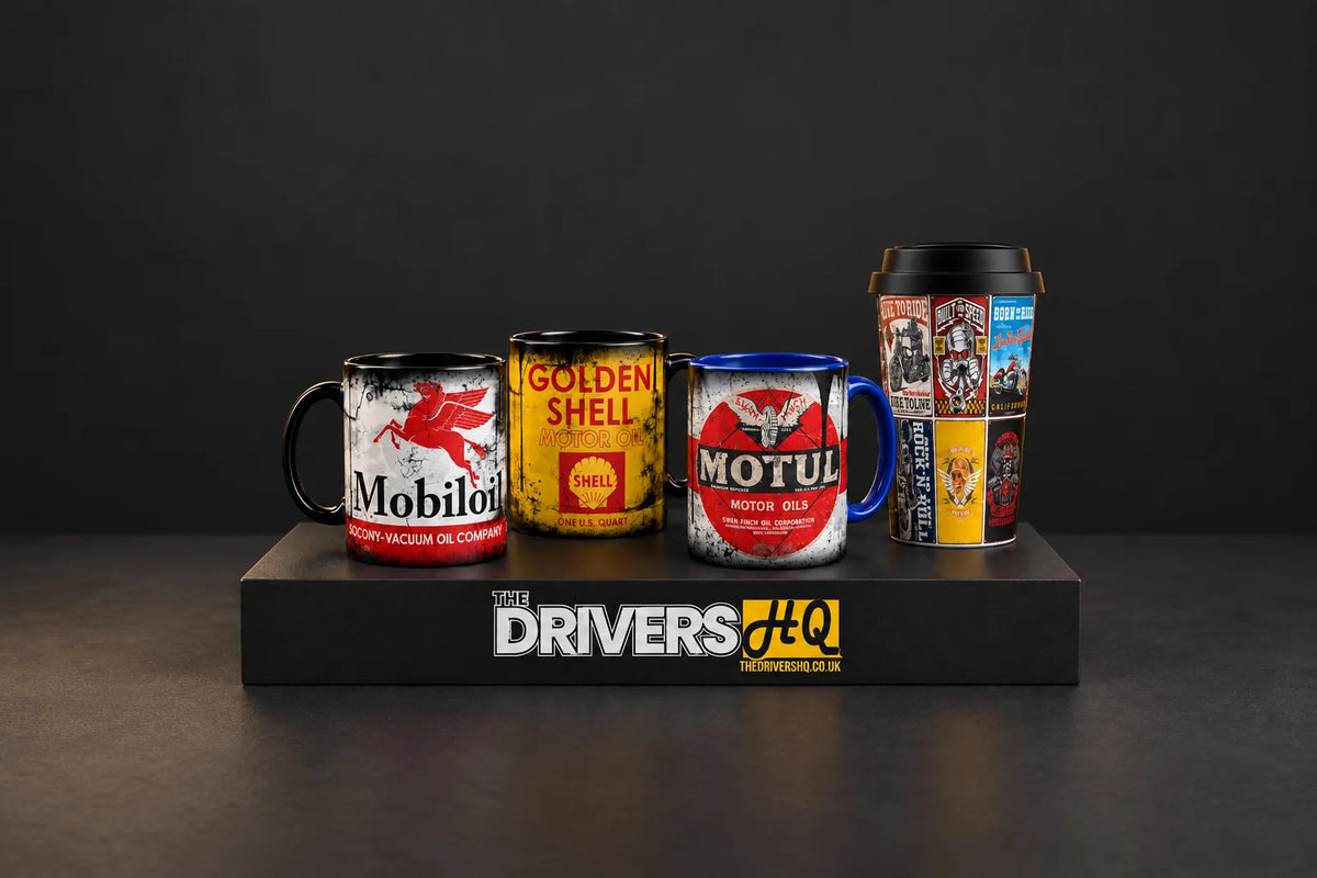 Sipfull of Design Mobiloil, Golden Shell and Motul vintage motor oil mugs with the Built for Speed travel mug on a black display plinth in a photo studio