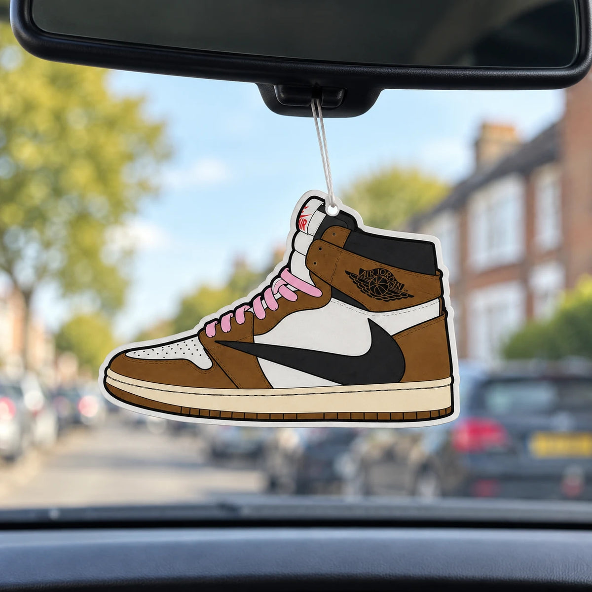 The Hyped Source Travis Scott AJ1 High Mocha air freshener hanging from a car rear-view mirror