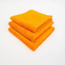 FibreKing Duplex edgeless cloth, three orange cloths folded and stacked on a white background