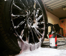 CarPro TRIX Iron And Tar Remover trigger bottle beside a foam covered alloy wheel