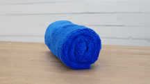 FibreKing Duplex edgeless cloth, a single blue cloth rolled up on a wooden table