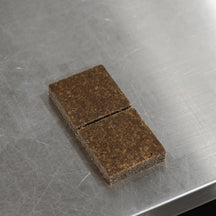Bio-Bombs Bio-Fresh Bar Vitamin C, unwrapped brown bar split into two halves on a metal surface