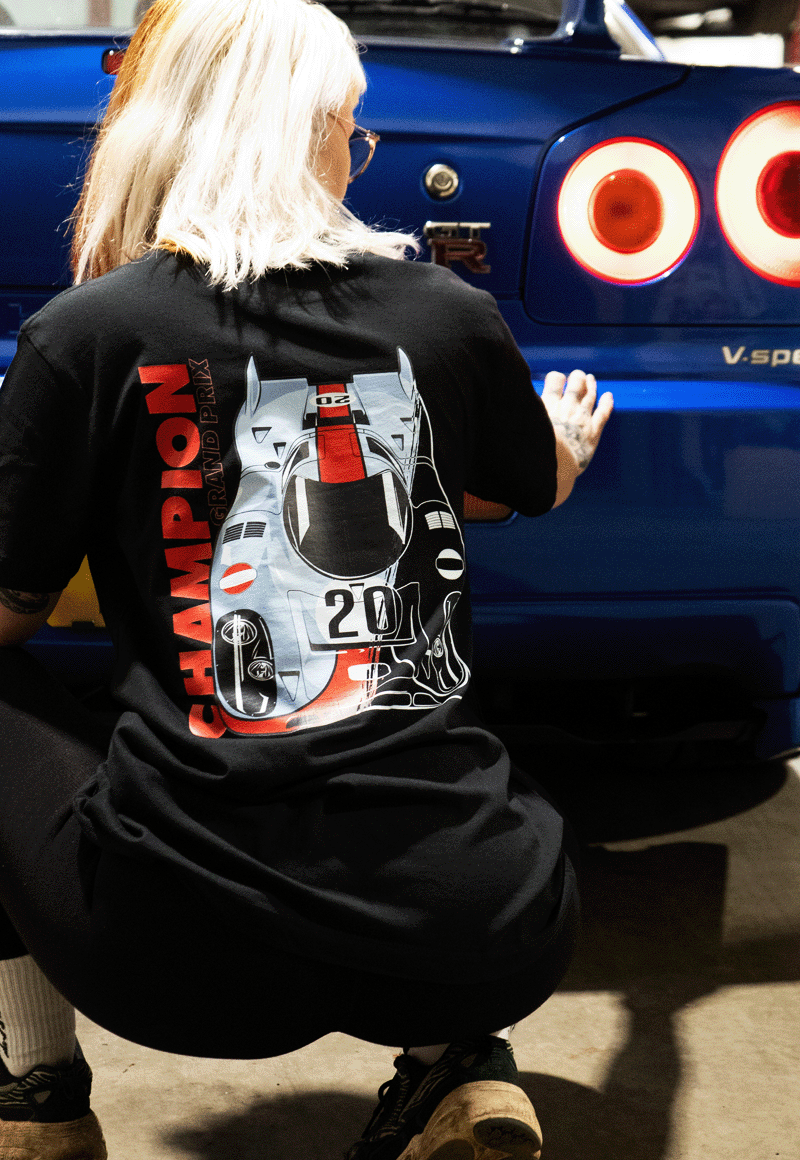 EuroStance Le Mans Racing Division Tee on a model crouching by a blue car, back print