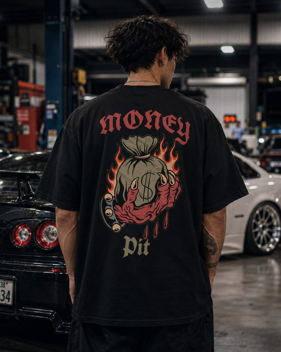 EuroStance Money Pit Tee, back of the black tee on a model beside parked cars