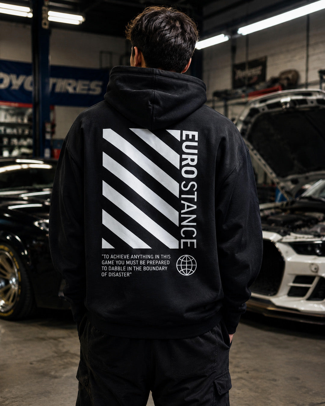 EuroStance OffStance Stirling Moss Hoodie black back on a model in a car workshop