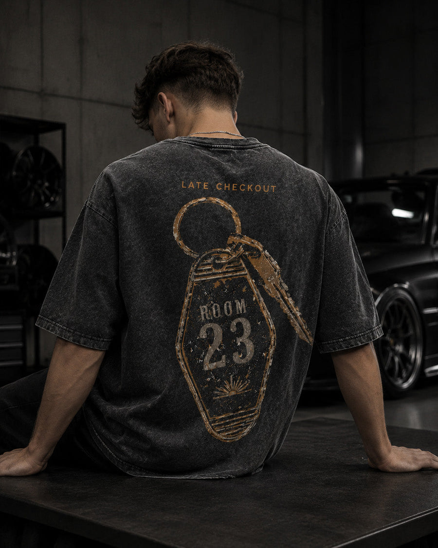 EuroStance Room23 T-Shirt worn seated in a garage, back view of the gold key tag print