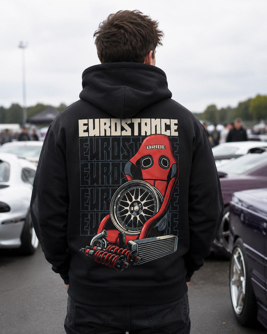 EuroStance Race Parts Hoodie in black, rear view on a model at an outdoor car meet