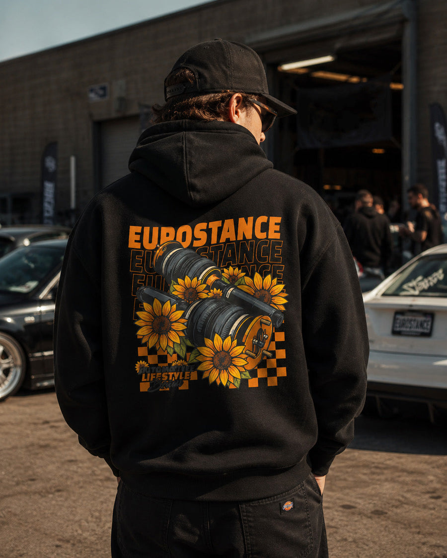 EuroStance SunFlowers Hoodie in black worn from behind with sunflower back print at a car meet