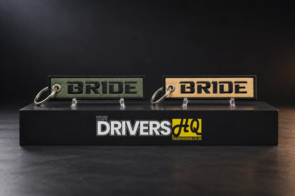 BRIDE Logo Flight Tag Key Chain, olive green and beige sides, on a black display plinth