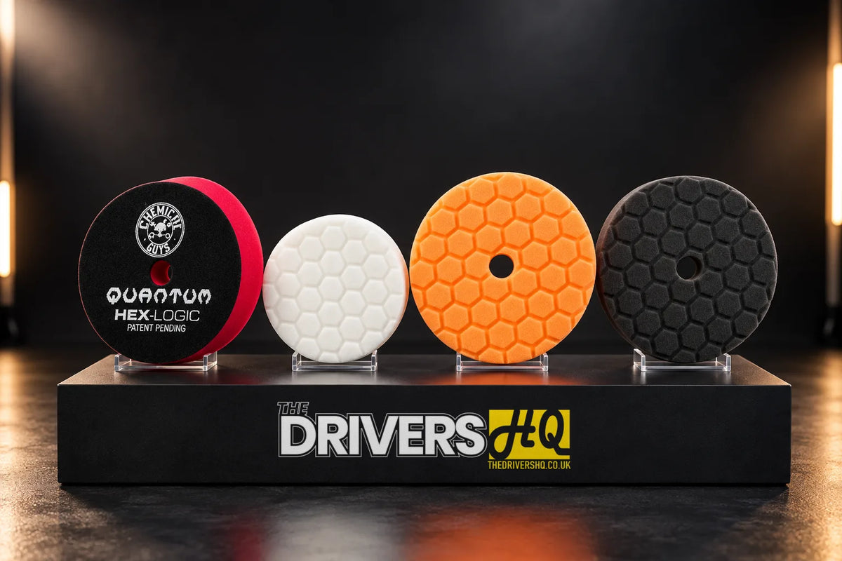 Chemical Guys HEX-Logic pads in red, white, orange and black on a black display plinth, the red Quantum pad showing its printed back