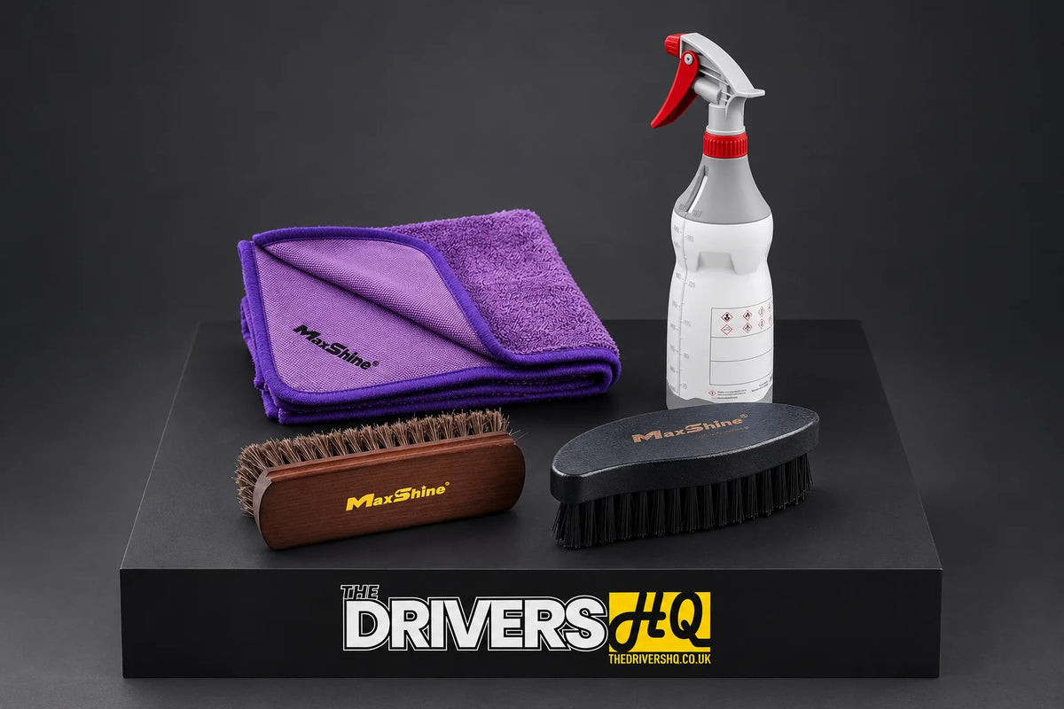 Maxshine horsehair brush, ergonomic tyre brush, purple twisted loop drying towel and chemical resistant trigger sprayer on a black display plinth in a photo studio