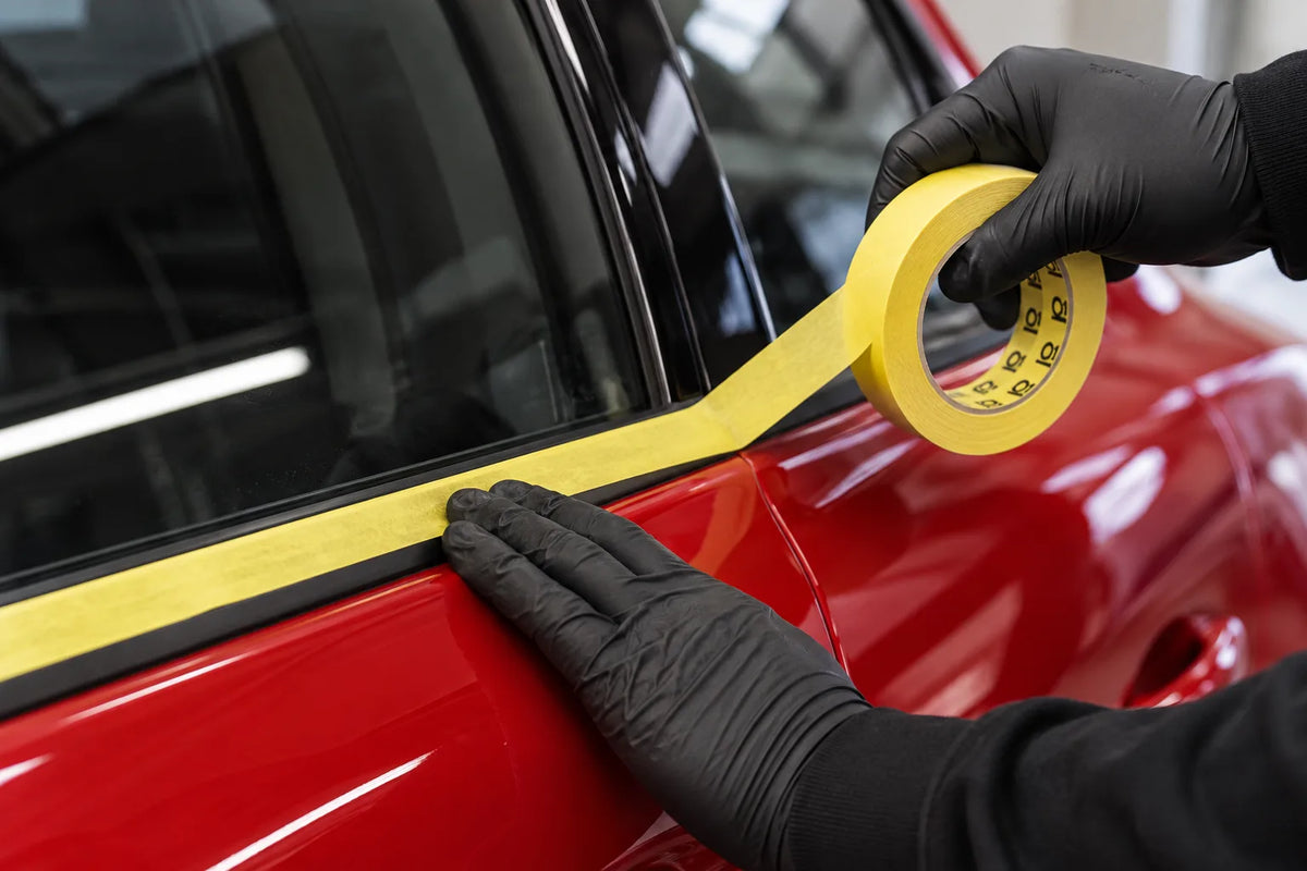 Q1 Precision Line yellow masking tape being run along the window trim of a red car