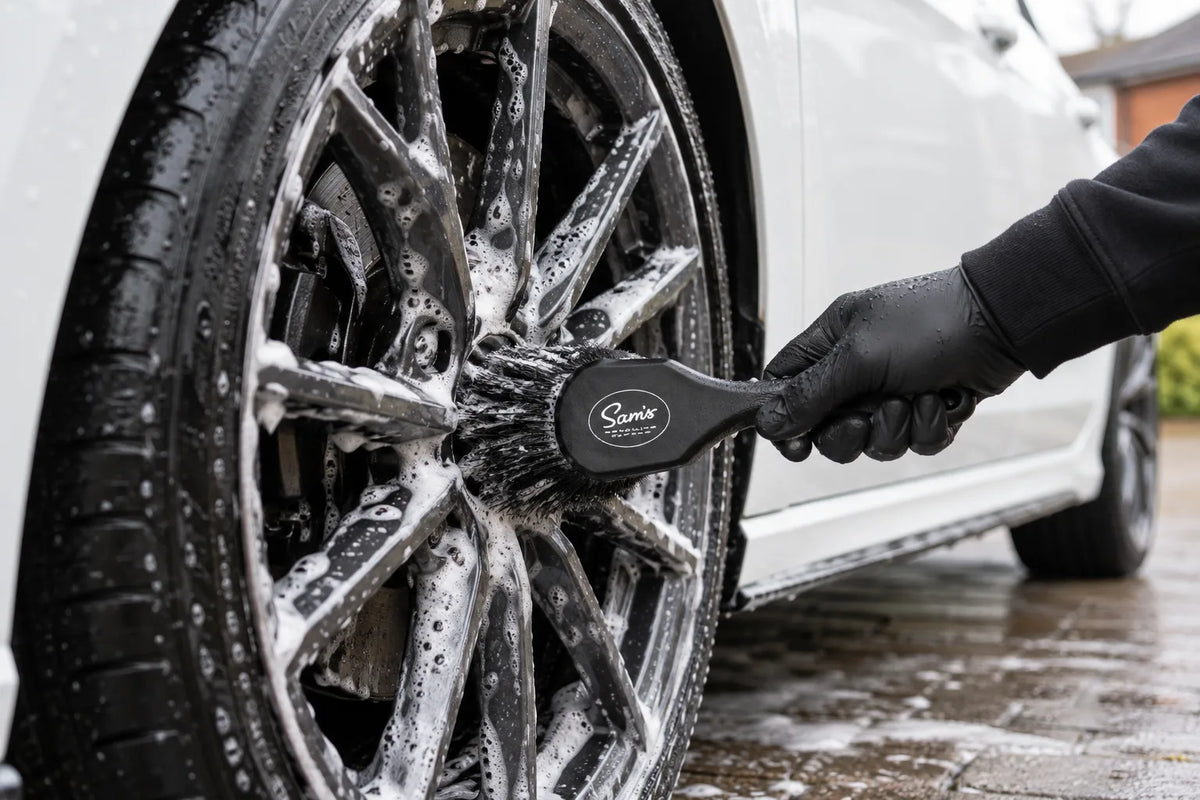 Sam's Detailing flagged tip wheel brush cleaning a foamed alloy wheel on a white car