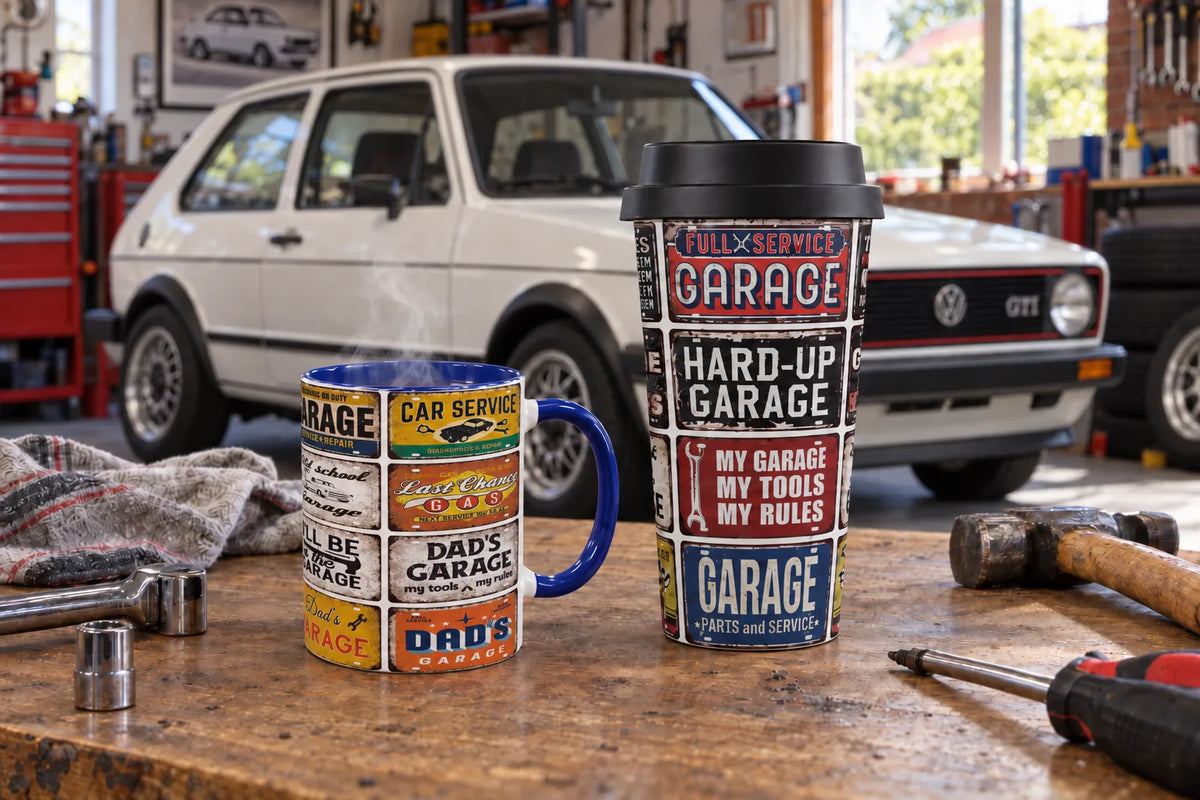 Sipfull of Design Dad's Garage mug and Hot Rod Dad travel mug on a workbench in a home garage with a white Volkswagen Golf GTI Mk1