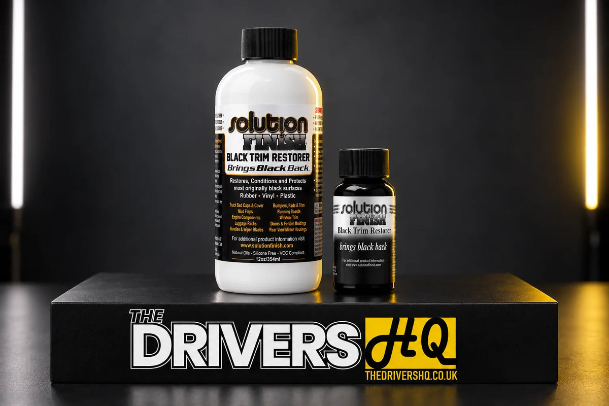 Solution Finish Black Trim Restorer 12oz and 1oz bottles on a black display plinth in a photo studio