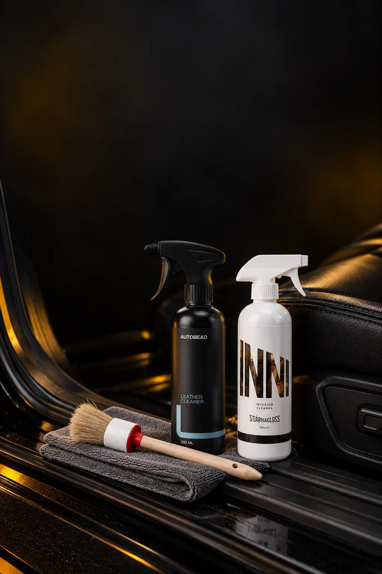 Interior care: AutoBead Leather Cleaner, Stjärnagloss Inni interior cleaner and a boar hair detailing brush on a grey microfibre cloth on the door sill of a black leather interior