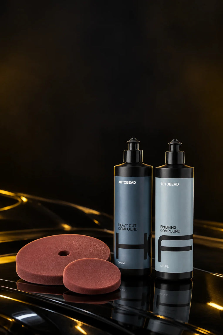 Correction kit: AutoBead Heavy Cut Compound and Finishing Compound with two Downforce Medium Cut foam pads on a glossy black bonnet