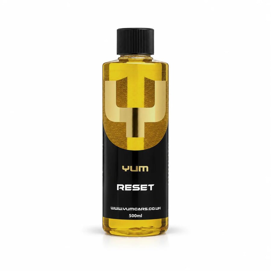 Yum Reset acidic shampoo 500ml bottle with golden yellow liquid, a black screw cap and gold Y mark, studio photo on white