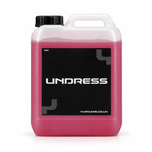 Yum Undress tyre and rubber cleaner 5 litre jerrycan with raspberry red liquid and a black UNDRESS label, studio photo on white