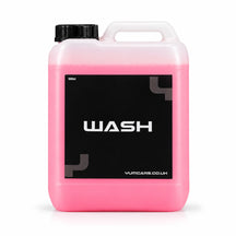 Yum Wash pH neutral shampoo 5 litre jerrycan with bright pink liquid and a black WASH label, studio photo on white