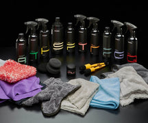 Autobead Detail Like a Pro kit with ten Autobead bottles, wax tub, foam pads, brushes, wash mitt and towels on a dark background